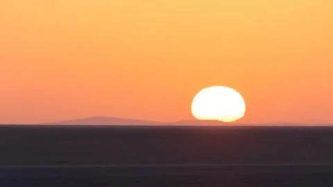 Sun rise in dasht e lut desert with big sun and flat ground Stock Photos
