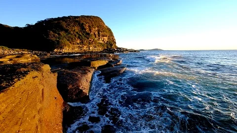 Sun rise slow motion waves crashing onto rocks winnie bay central coast nsw Stock Footage 93604248