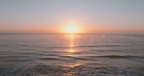 Sun rises above ocean, marking the start of a new day. Stock Footage 303314096