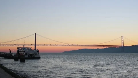The sun rises above the river bridge with the ship on the dock Stock Footage 130116439