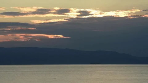 The sun rises on the beach of Taormina with threatening clouds Video stock 83914100