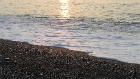 The sun rises on the beach while the waves break on the shoreline Stock Footage 83914660