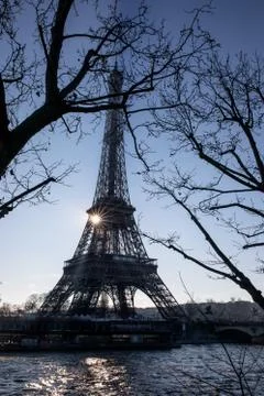 The sun rises behind the Eiffel Tower on the Seine River, Paris Stock Photos