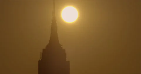 The sun rises behind the Empire State Building early morning Stock Footage 67297483