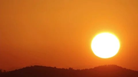 The sun rises from behind a hill Stock Footage 96709478