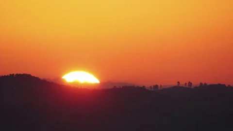 The sun rises from behind a hill It s like a round ball, giant yellow light O Stock Footage 72266994