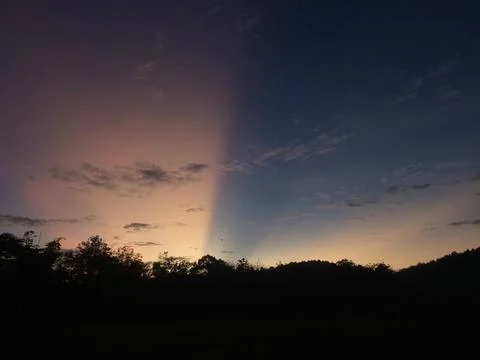 The sun rises from behind the hill Stock Photos
