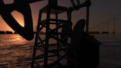 The sun rises behind a large oil field. Infinity loop. 3d rendering Stock Footage 132086581