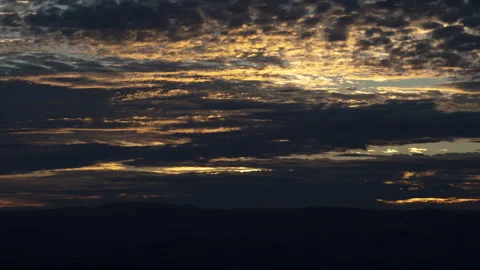 Sun Rises Behind Mostly Cloudy Sky Zoom In Timelapse Video stock 260575405
