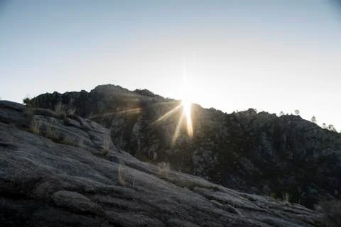 Sun rises behind the mountains Stock Photos