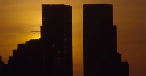 The sun rises behind the Towers of Columbus Circle in Manhattan Stock Footage 62344366