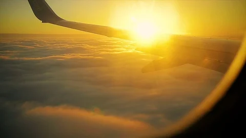 Sun Rises from Behind the Wing of the Aircraft at Sunrise view from the Window Stock Footage