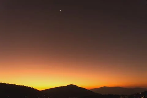 The sun rises Orange light behind a big mountain Stock Photos