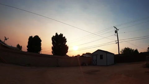The sun rises over a backyard in suburban United States on a clear autumn Stock Footage 140534429