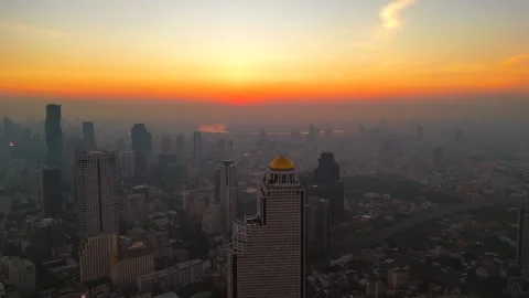 Sun rises over the horizon behind Bangkok city high-rise buildings and Chao Stock Footage 304847459