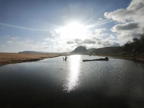The sun rises over the river estuary, where the river meets the coast. 스톡 사진