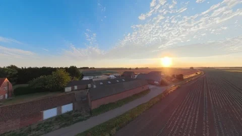 Sun rises over rural farmsteads, casting golden glow 库存影片 342555277