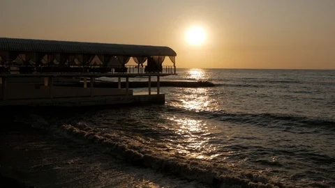 The sun rises over the sea at dawn. Sea surf and pebbles in the morning sun. Stock Footage 120435971