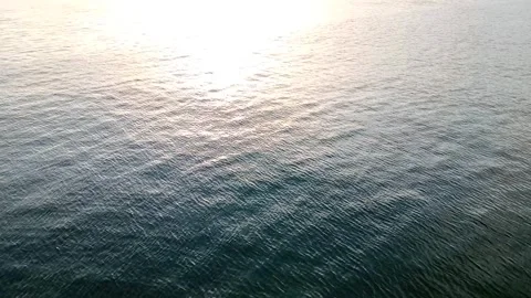The sun rises over the small wavy ocean Stock Footage 277821635