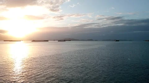 The sun rises over the small wavy ocean Stock Footage 277821651