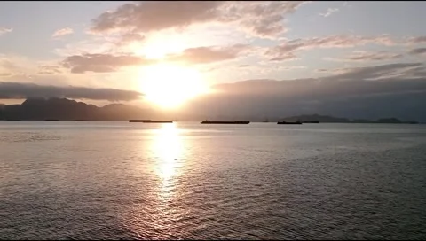 The sun rises over the small wavy ocean Stock Footage 277822865