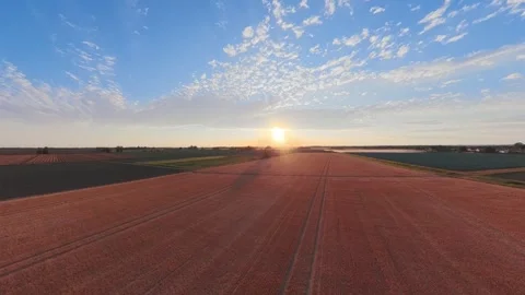Sun rises over vast red earth fields 库存影片 342589051
