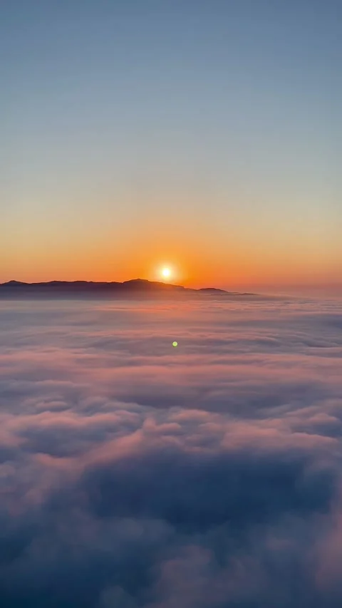 Sun rising above a dense sea of clouds seen from Montserrat Stock Footage 344409746