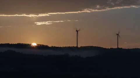 Sun rising behind forest and windturbines Stock Footage 62008499