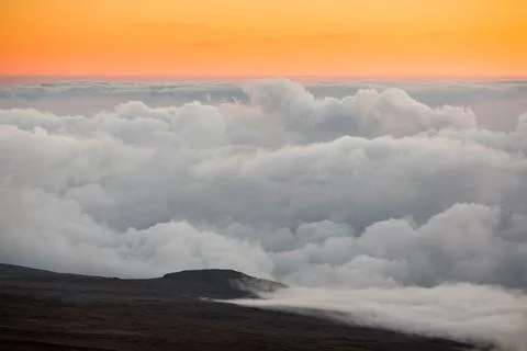 The sun rising over the clouds which line Mount Kilimanjaro. Stock Photos