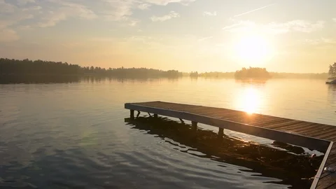 Sun rising over dock at Stony Lake, Ontario, Canada. Stock Footage 94179531