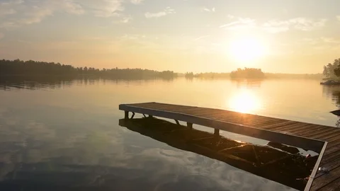 Sun rising over dock on Stony Like, Ontario, Canada. 库存影片 94242215