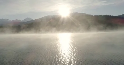 Sun Rising Over A Mountain And A Mist Shrouded Lake Video stock 82808188