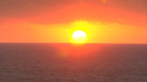 Sun rising over ocean. Orange sky and blue water Stock Footage 106842881