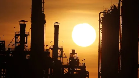 Sun rising over petrochemical plant Stock Footage