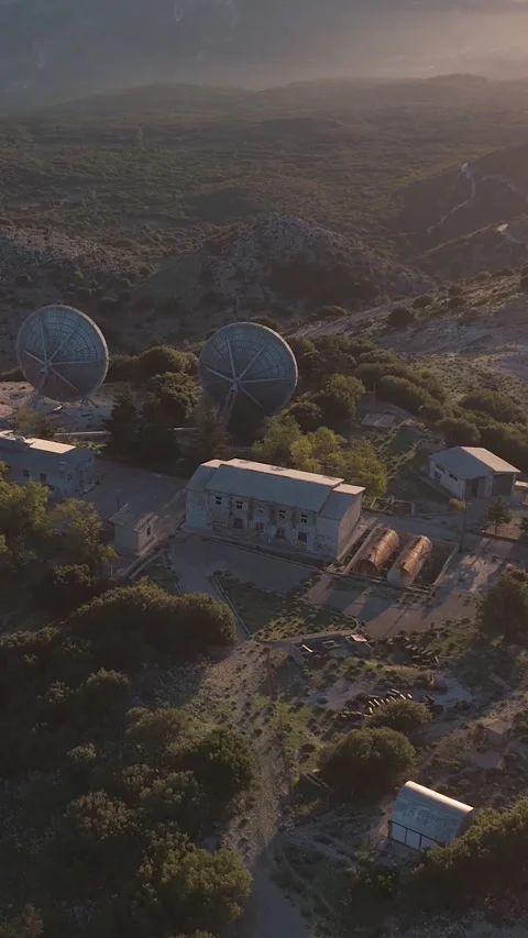 Sun rising over satellite dish array revealing mountain range Video stock 290449874