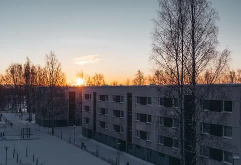 Sun is rising in the suburbs behind the panel houses on a winter morning Stock Photos