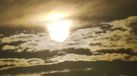 Sun rising through dramatic moving clouds, going out of frame with a flare Stock Footage 40931088
