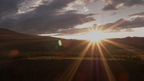 The sun 's rays break through the clouds in the mountains. Orange sunset. 4K. Stock Footage 126721592
