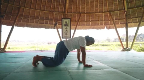 Sun salutation part with Downward-Facing Dog pose by balinese man doing yoga Stock Footage 68084539