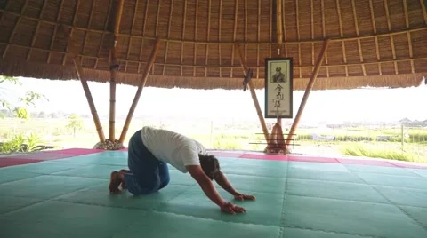 Sun salutation part with eight limb pose, by balinese man doing yoga Stock Footage 68084531
