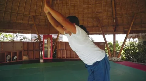 Sun salutation part with Standing Forward Bend pose by balinese man doing yoga Stock Footage 68084541