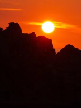 Sun set behind cliffs Stock Photos