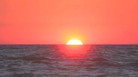 Sun set down by half over the rippling sea Stock Footage 8365974