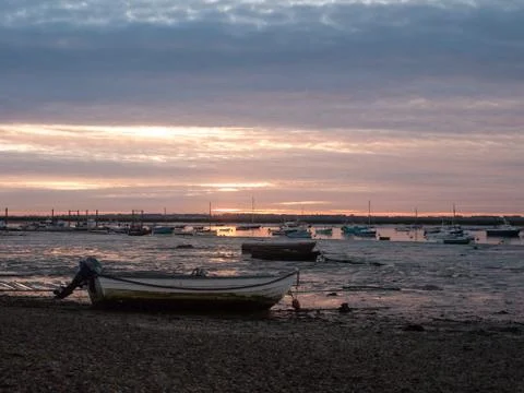 Sun set sky dramatic clouds sea front beach harbor marina boats moored landsc Stock Photos