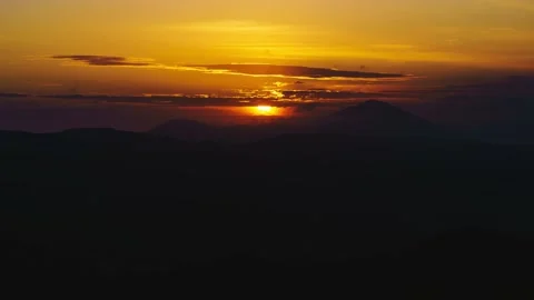The sun sets against the backdrop of mountains and clouds of timelapse sunset Stock Footage 142318812
