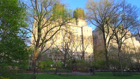 The sun sets among Central Park West buildings beyond the Central Park. Vídeo Stock 306275170