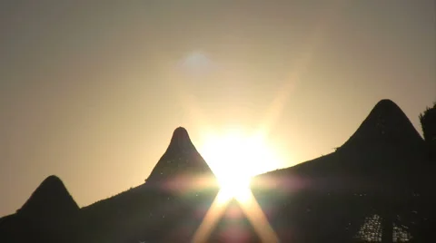 Sun sets behind beach parasols 01 스톡 동영상 1093311