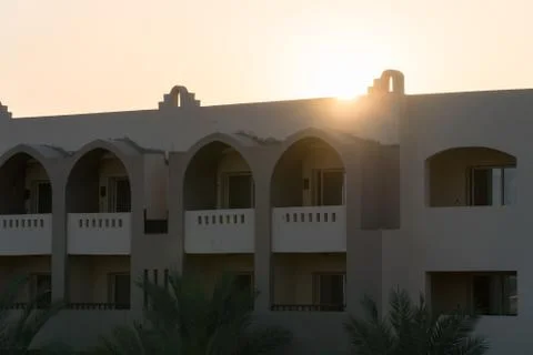 The sun sets behind the building Stock Photos