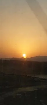The sun sets behind the desert. 库存照片
