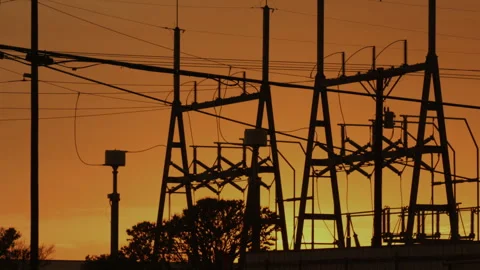 The sun sets behind an electric power relay station grid, 4K. Stock Footage 244995253